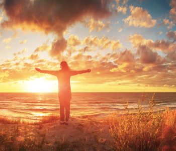 View of a happy woman on the sunset beach